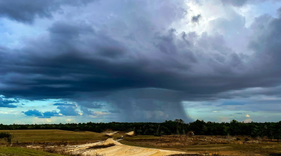 A thin wall of rain can be seen coming down intently in a small patch in the distance.