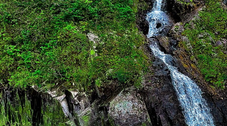Just beyond the Aialik glacier, small waterfalls run down the hillsides from the glacier.