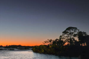 The sun sets behind a small island just of the shore of Cedar Key, Florida.