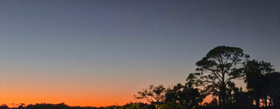 The sun sets behind a small island just of the shore of Cedar Key, Florida.